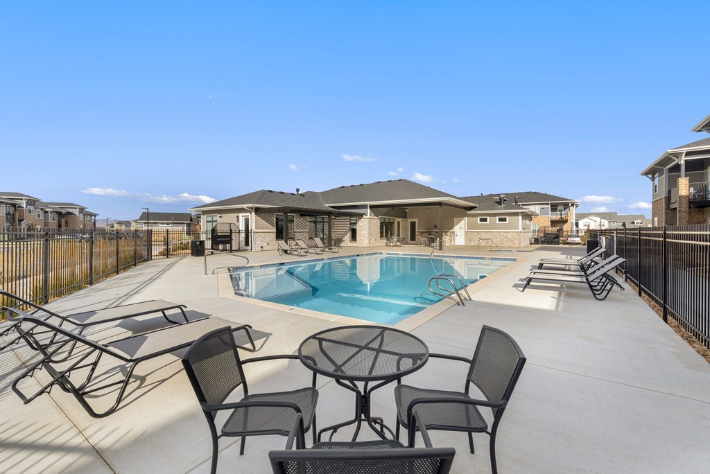 our apartments have a swimming pool with chairs and tables