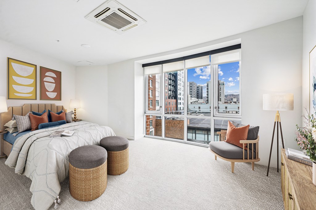 a bedroom with a bed and a large window