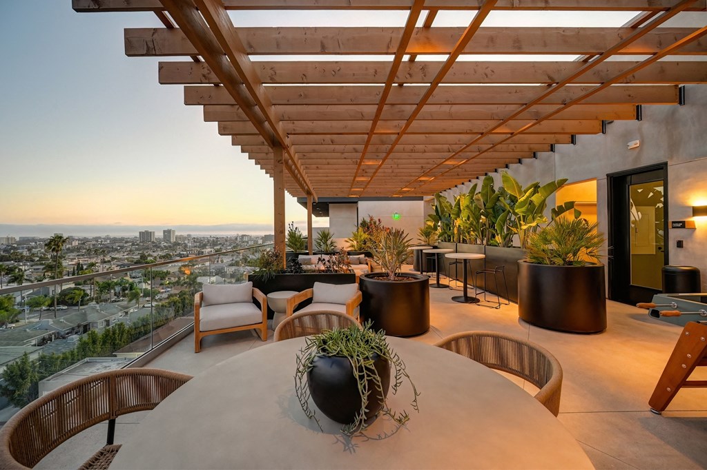 a terrace with a table and chairs and a view of the city