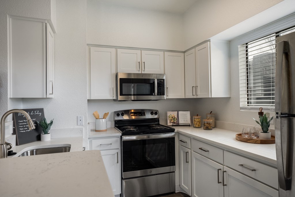 a kitchen with stainless steel appliances and white cabinets