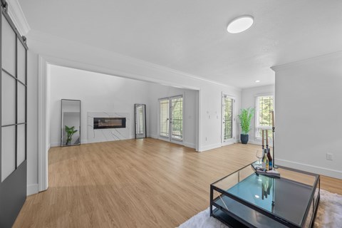 A modern living room with a glass coffee table in the center.