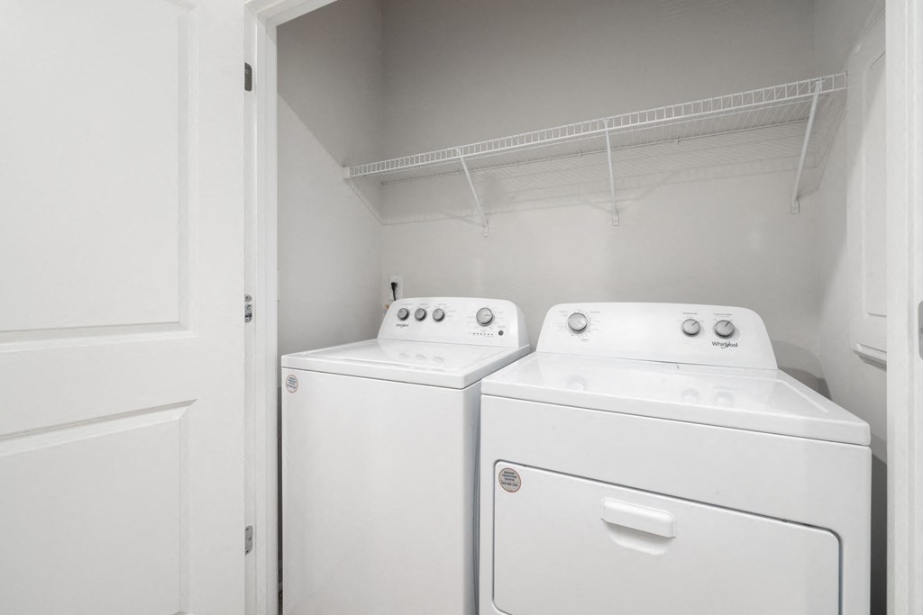 a washer and dryer in a white room with a white door