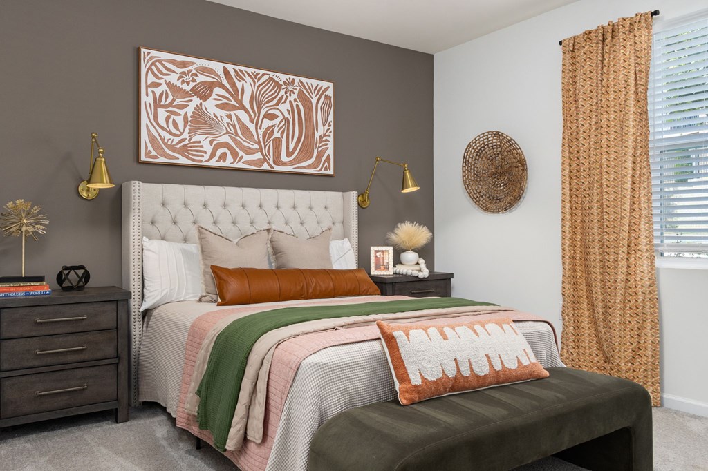 A bedroom with a large bed and a decorative wall hanging.