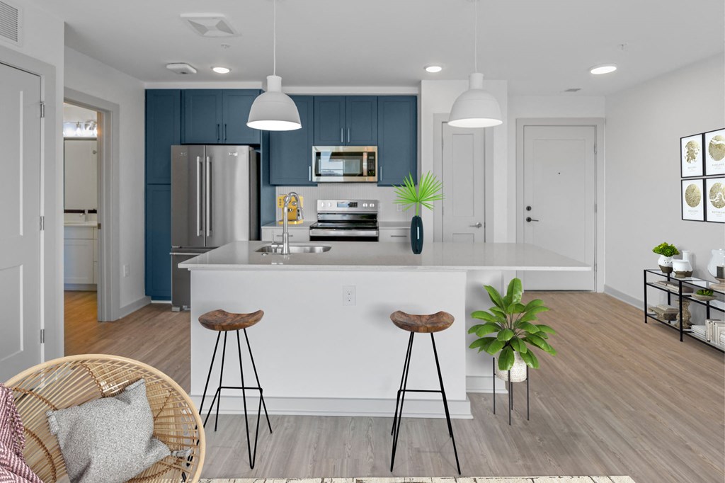a kitchen with a large white island with two stools in front of it