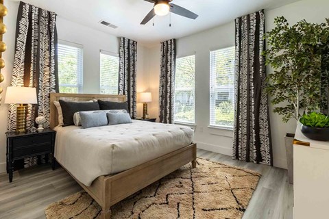 A bedroom with a large bed and a ceiling fan.