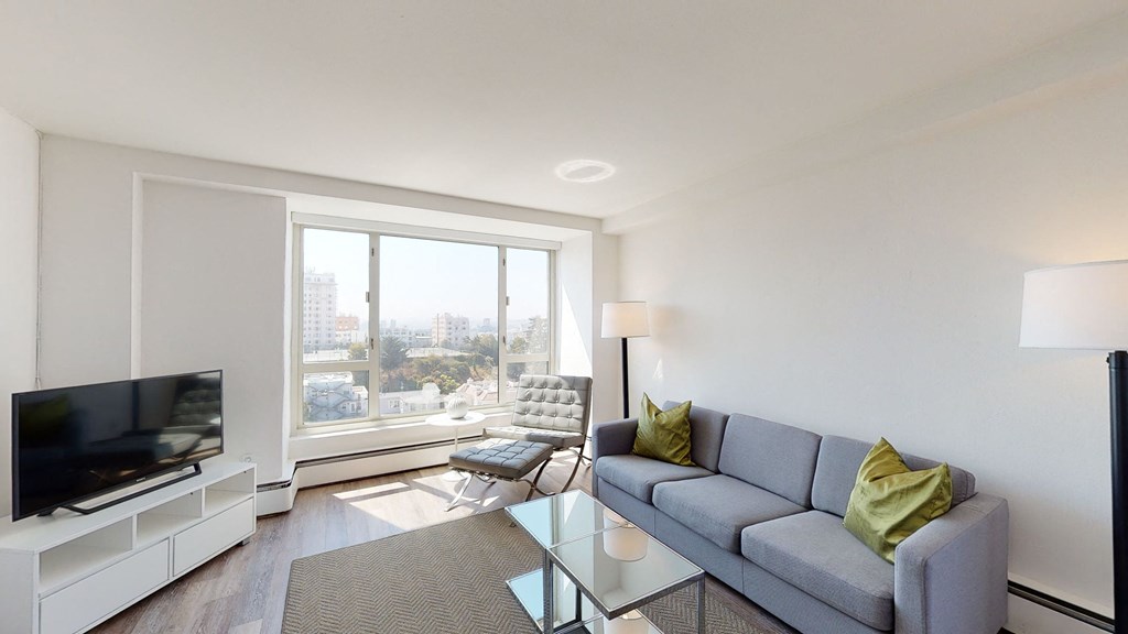 a living room with white walls and a large window