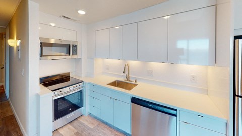 a white kitchen with blue cabinets and a sink