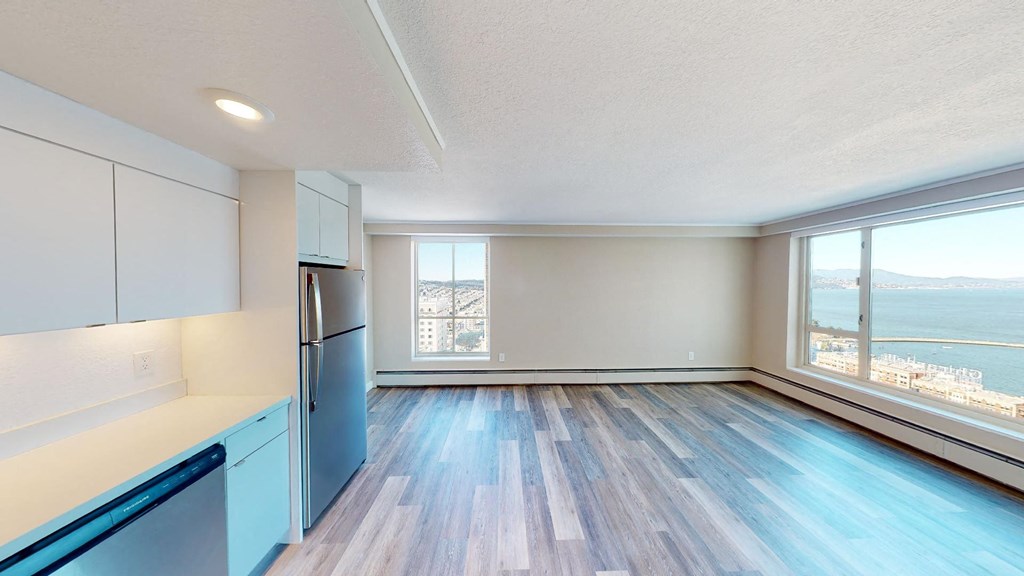 an empty kitchen and living room with a large window and a view of the water