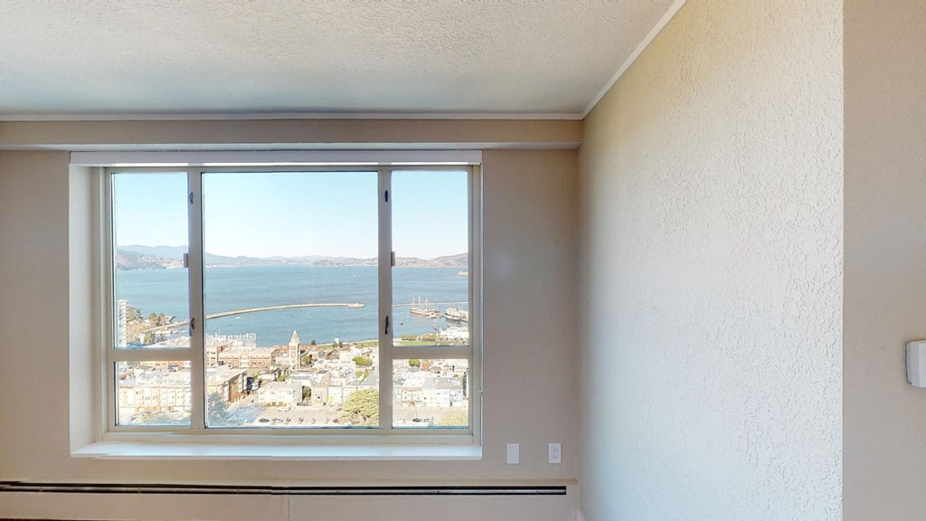 a bedroom with a large window and a view of the water