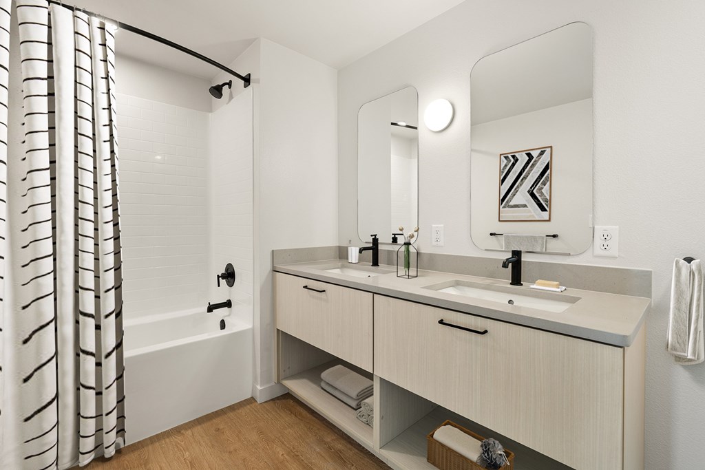 A bathroom with a white tub and sink.