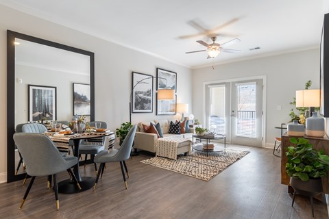 A modern dining room with a large mirror and a dining table set with plates.