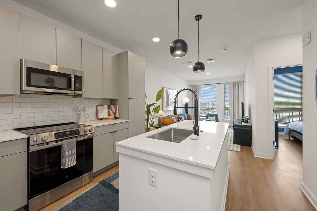 A modern kitchen with a stove top oven and microwave above it.