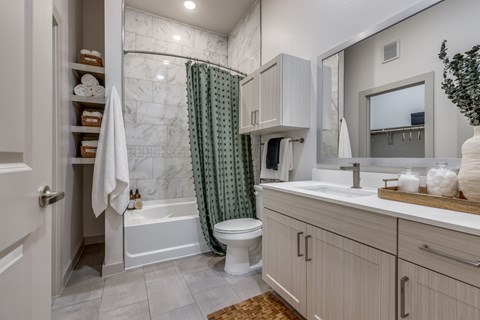 A bathroom with a white toilet, a white sink, and a white shower curtain.