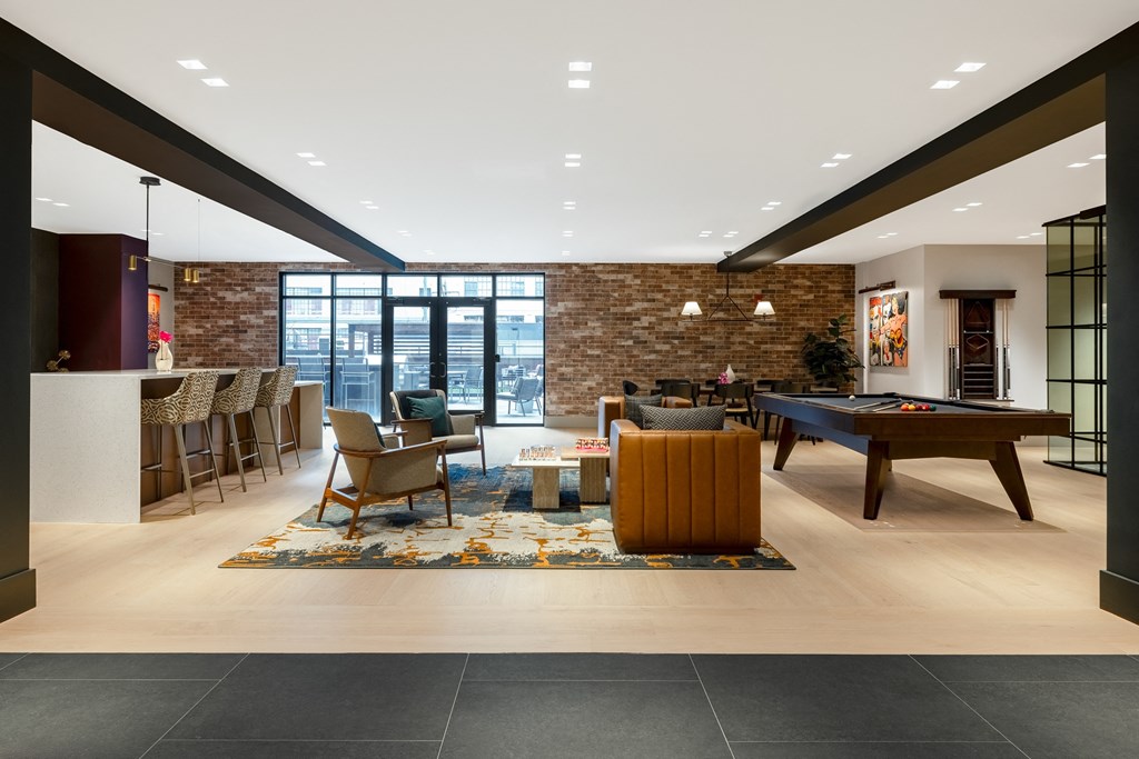 a living room with a pool table and a bar
