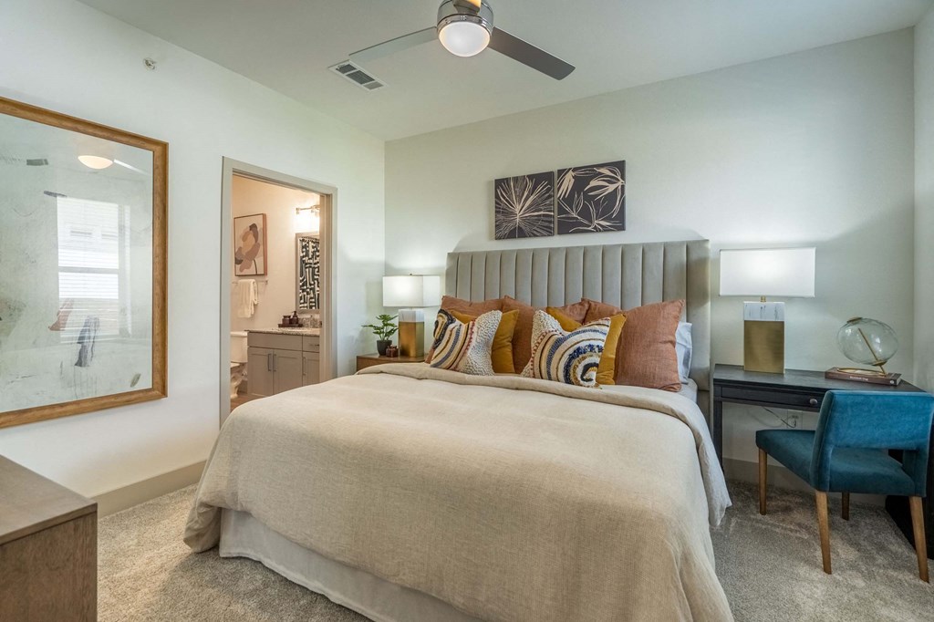 a bedroom with a large bed and a ceiling fan