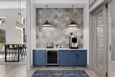 A kitchen with a stone wall and a counter with a coffee maker.