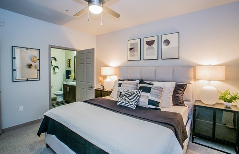 A bedroom with a large bed and a ceiling fan.