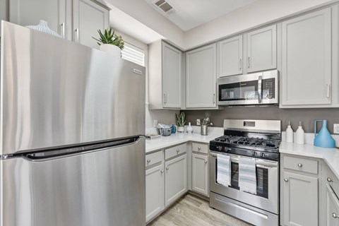 A modern kitchen with a stainless steel refrigerator and oven.