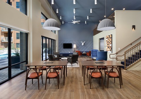 A modern dining room with a long table and chairs.