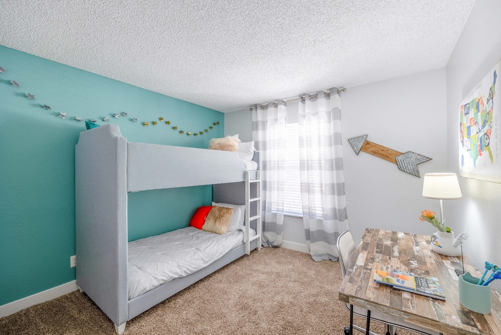 a bedroom with a bunk bed and desk