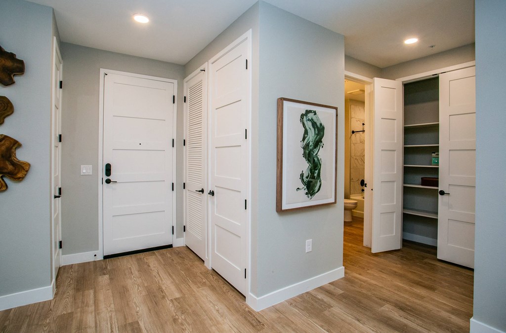 a bedroom with two closets and a bathroom in the background
