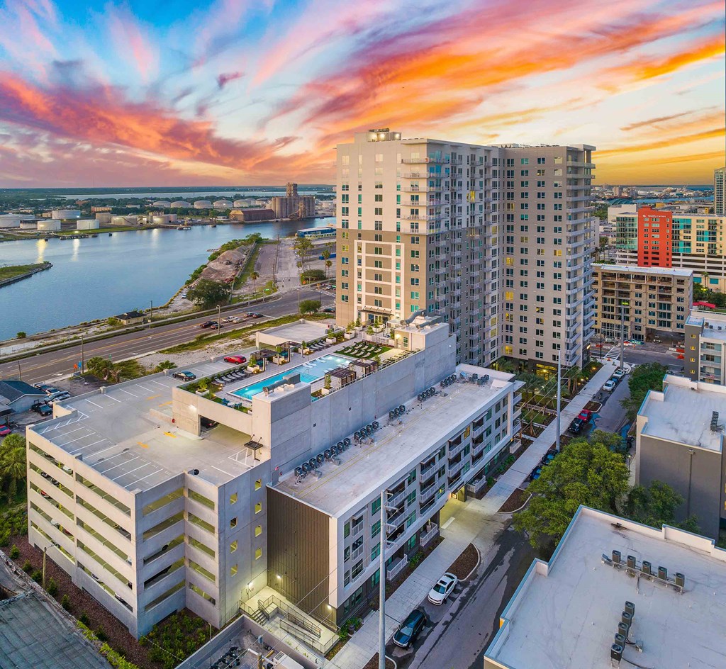 an aerial view of an apartment complex with a sunset over the water