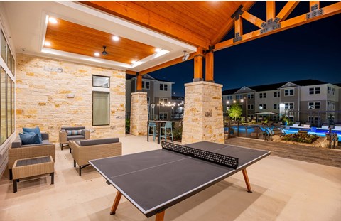 a ping pong table in an outdoor patio with a pool