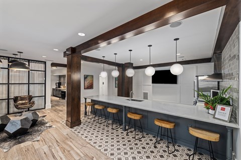 A modern bar area with wooden beams and a white counter.