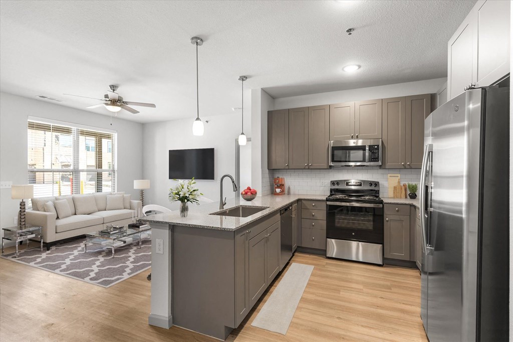 a kitchen with a large center island next to a living room with a couch and a tv