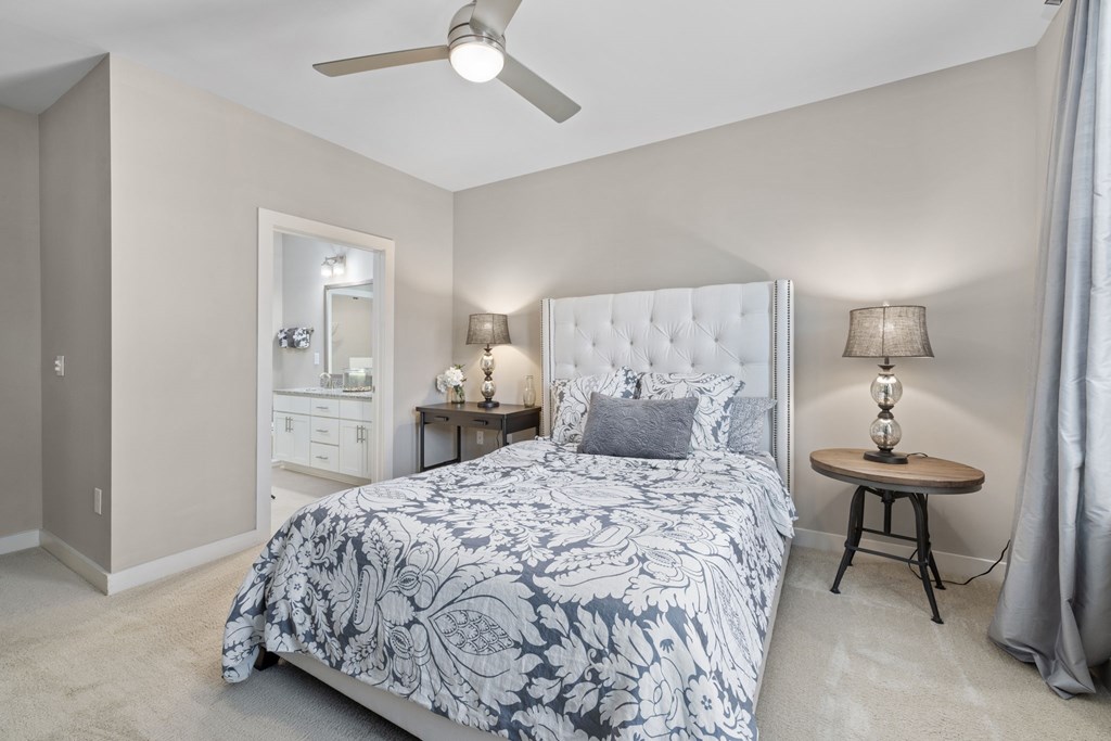 A bedroom with a large bed and a ceiling fan.