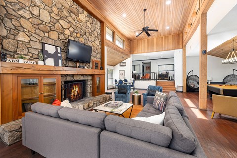 A living room with a stone wall and a fireplace.