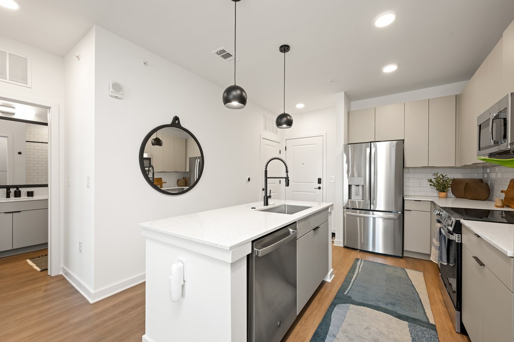 A modern kitchen with a white island and stainless steel appliances.