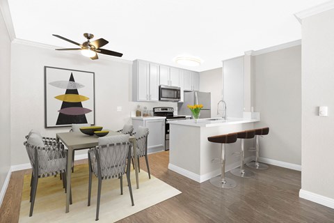 A kitchen with a table and chairs and a ceiling fan.