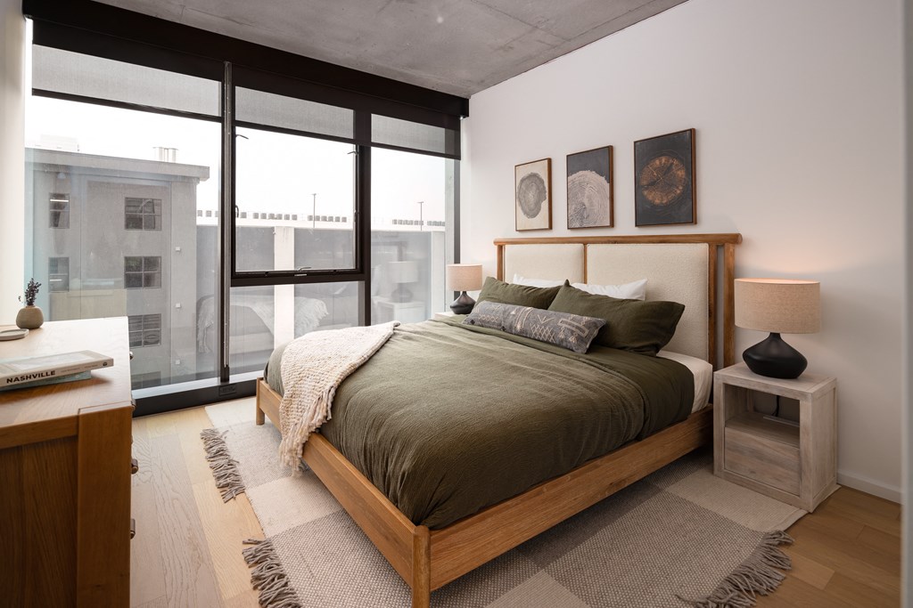 a bedroom with a bed and a large window