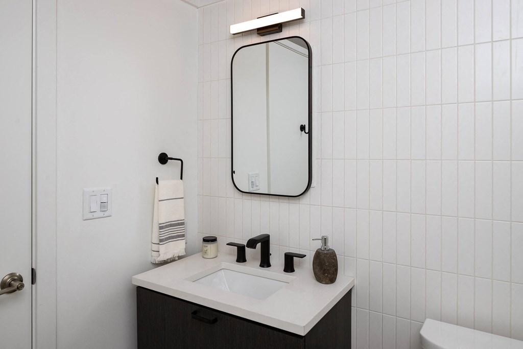 a white bathroom with a sink and a mirror