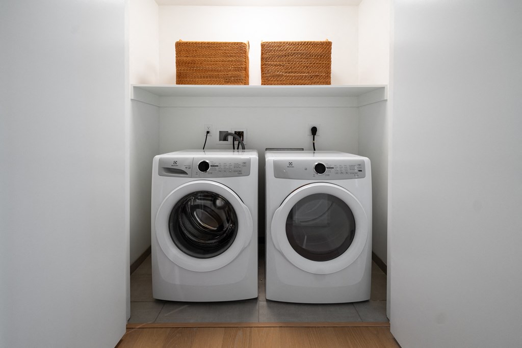 a laundry room with a washing machine and a washer and dryer