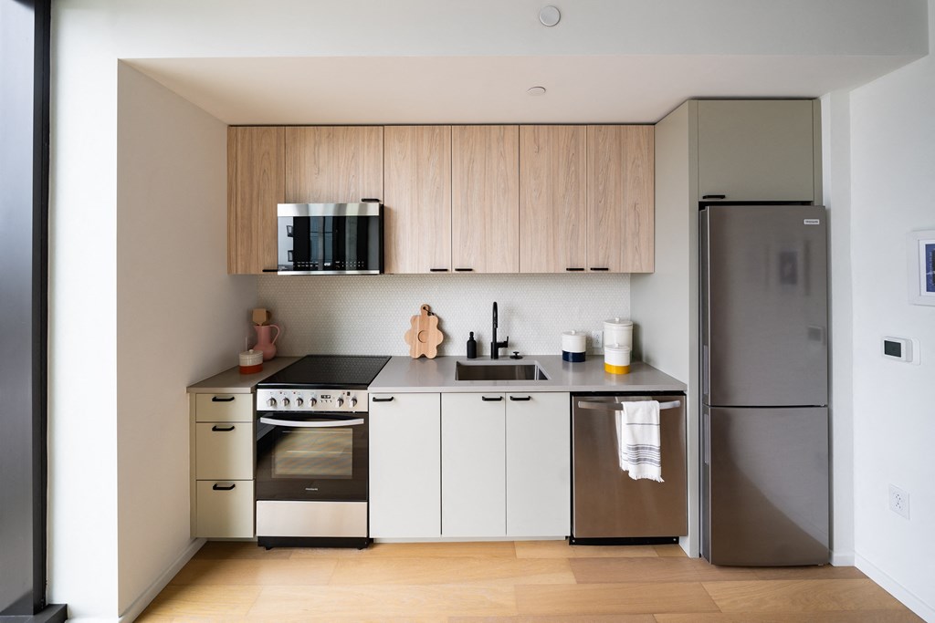 a small kitchen with white cabinets and stainless steel appliances