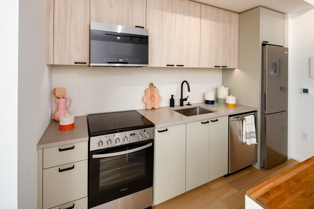 a kitchen with white cabinets and stainless steel appliances and a sink