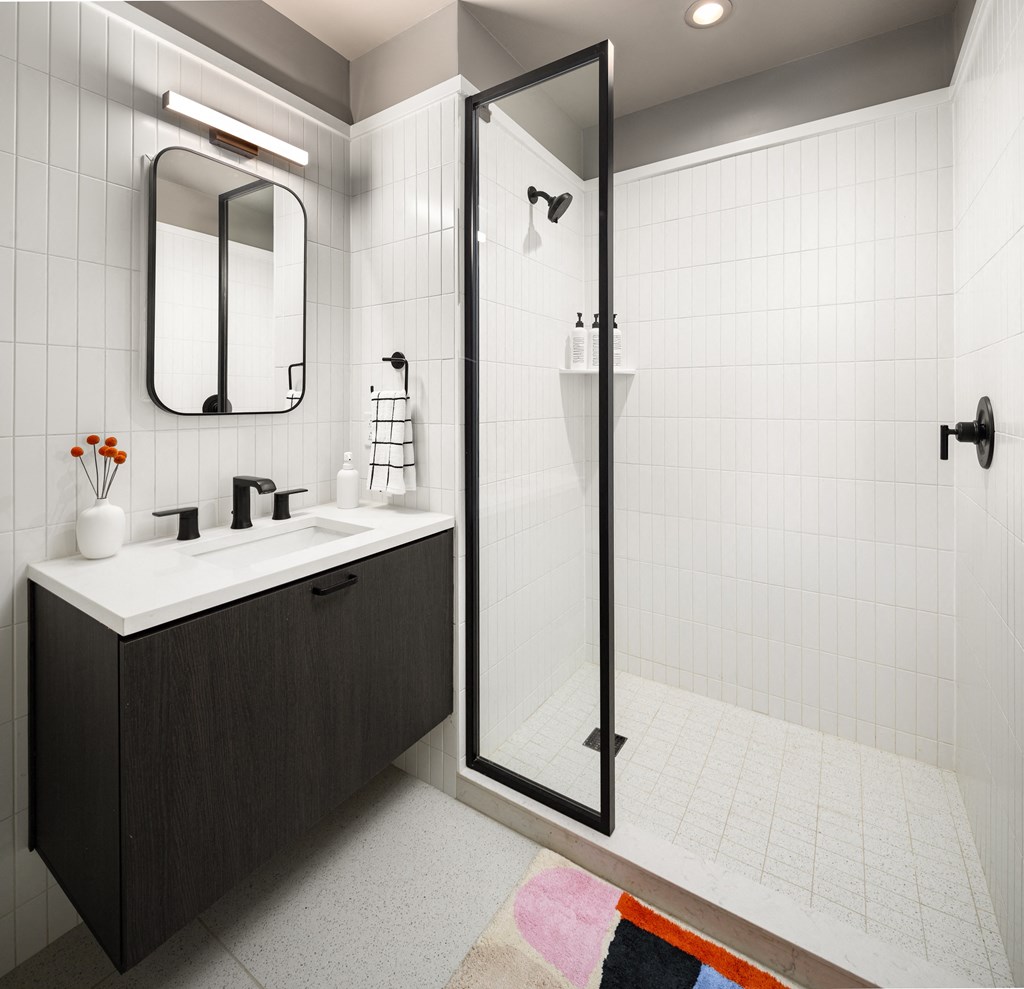 a bathroom with a shower and a sink and a mirror