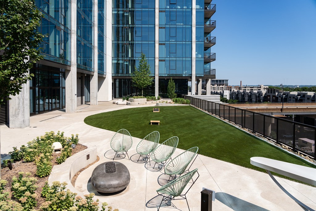 an outdoor area with chairs and a lawn in front of an office building