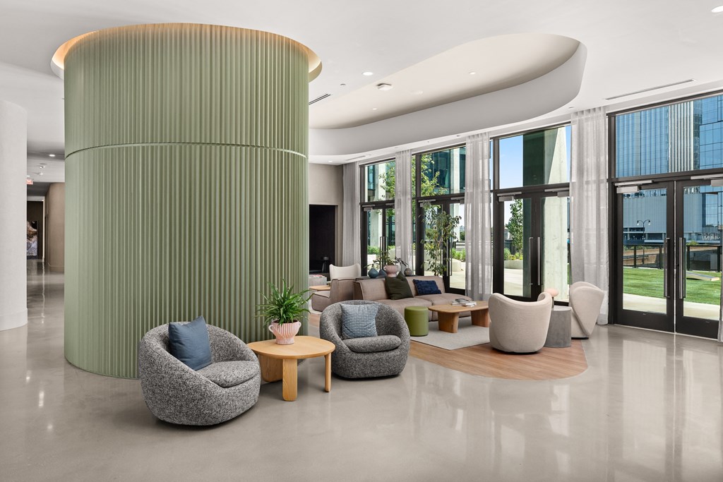 a lobby with couches and chairs and a large green pillar