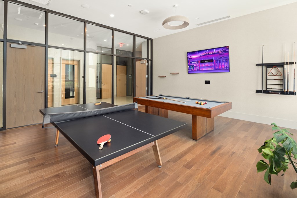 a games room with two ping pong tables and a television