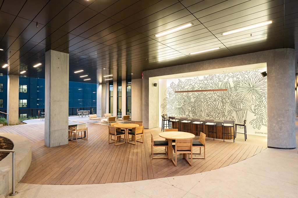 a large room with tables and chairs and a mural on the wall