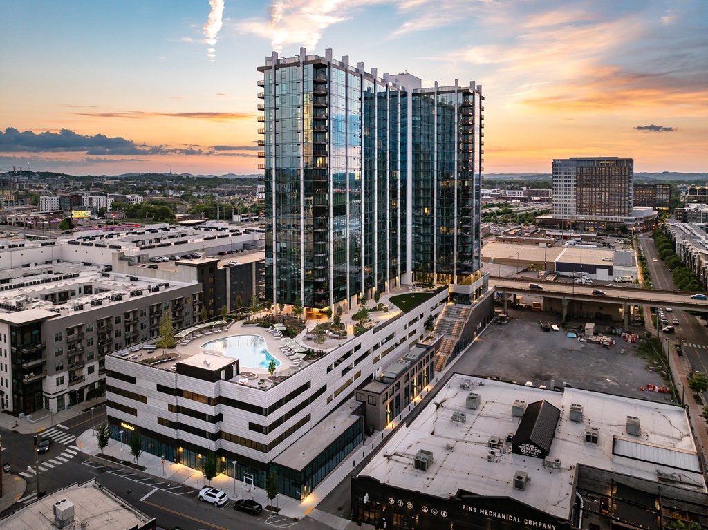 an aerial view of a city with a tall building and a pool