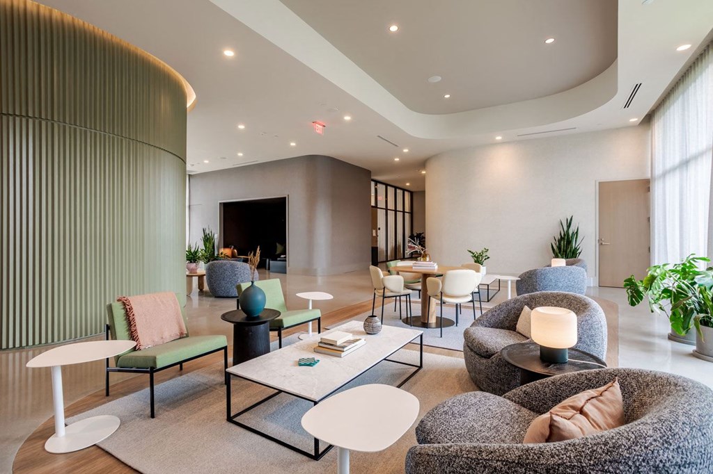 a lobby with couches chairs and tables and a fireplace