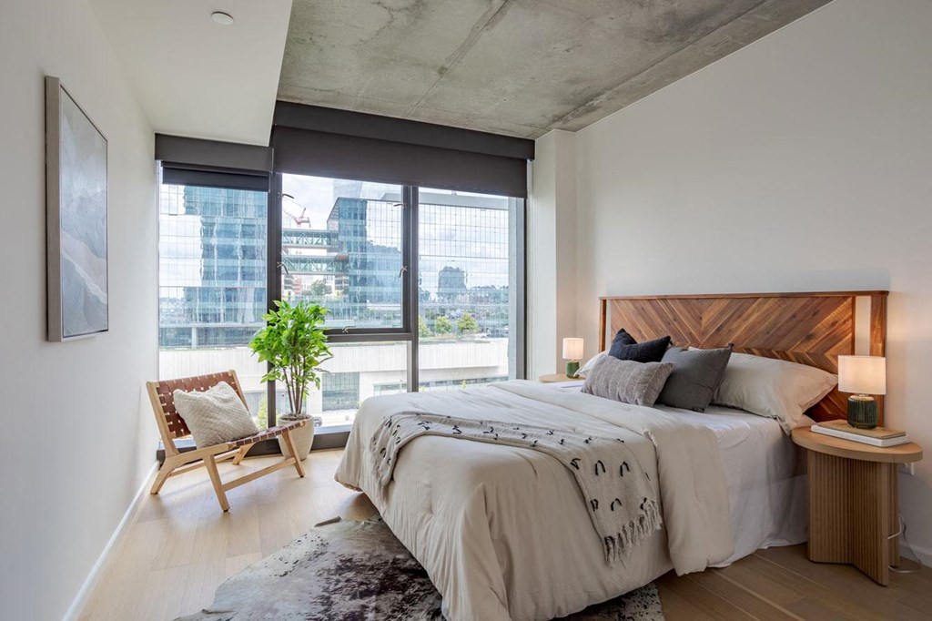 a bedroom with a bed and a large window