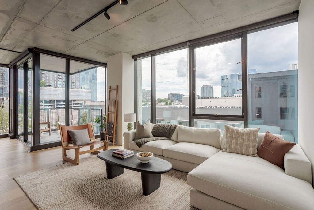 a living room with a couch and a coffee table and a view of a city
