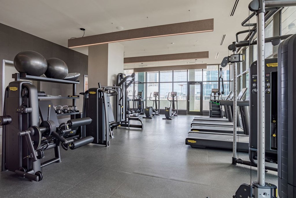 a gym with weights and other exercise equipment and a large window