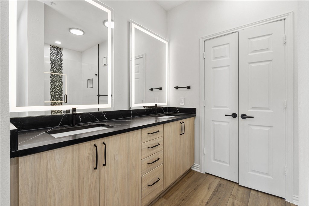 a bathroom with a sink and two mirrors