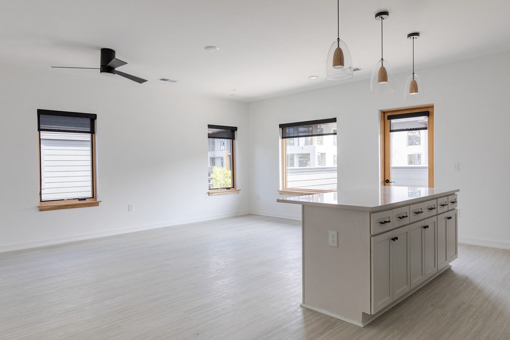 an empty kitchen and living room with white walls and wood floors